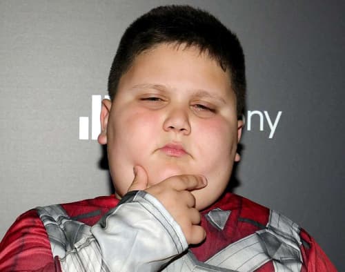 The Rizzler, the young boy the internet adopted as the solemn embodiment of rizz, regarding the camera without a flicker